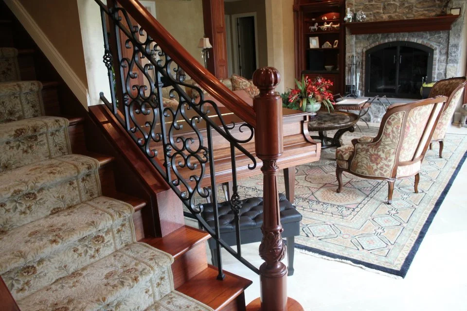 Staircase with ornate iron balusters and newel post